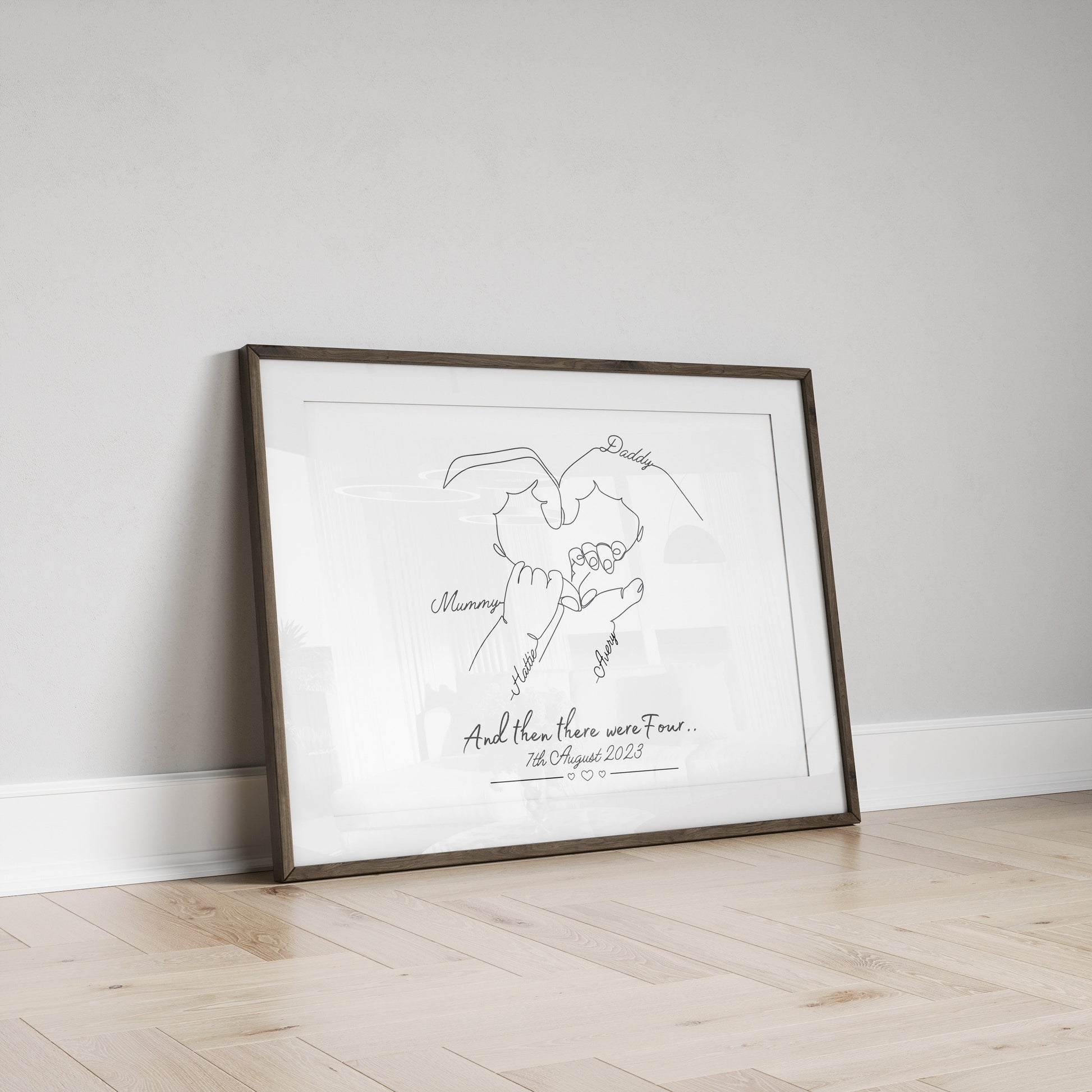 A framed black and white line drawing of four hands forming a heart shape. The hands are labeled 'Daddy', 'Mommy', 'child's name'. The text below the drawing reads 'And then there were four... then the date.