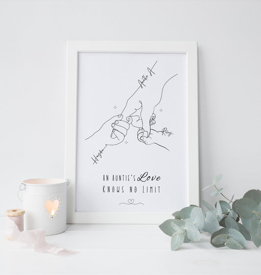 A framed minimalist line art print hanging featuring an illustration of an aunt holding the hands of her nieces or nephews. The simple black line drawing shows delicate hands each labeled with names and The phrase “An Aunty’s Love Knows No Limit”
