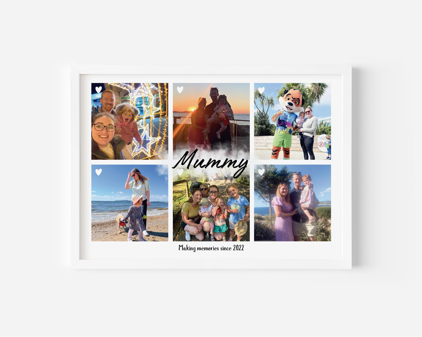 A framed personalized photo collage featuring six family pictures arranged in a grid. The center of the collage has the word &#39;Mummy&#39; written in elegant script, with the phrase &#39;Making memories since 2022&#39; below it. The photos capture various moments, including beach outings, family gatherings, and fun activities with a child. The frame is white, and small heart icons are placed on some of the images, adding a sentimental touch.