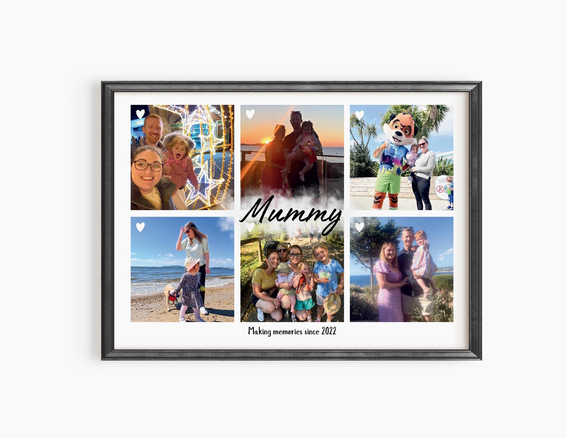A framed personalized photo collage featuring six family pictures arranged in a grid. The center of the collage has the word &#39;Mummy&#39; written in elegant script, with the phrase &#39;Making memories since 2022&#39; below it. The photos capture various moments, including beach outings, family gatherings, and fun activities with a child. The frame is white, and small heart icons are placed on some of the images, adding a sentimental touch.